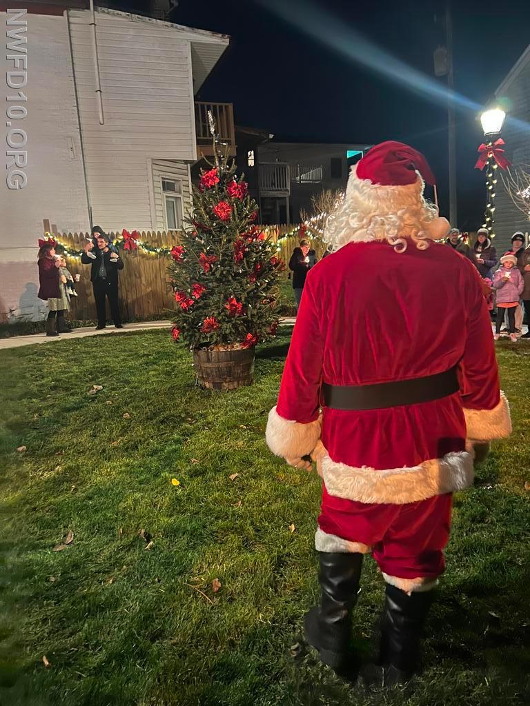 Santa Claus Lighting the Town Tree